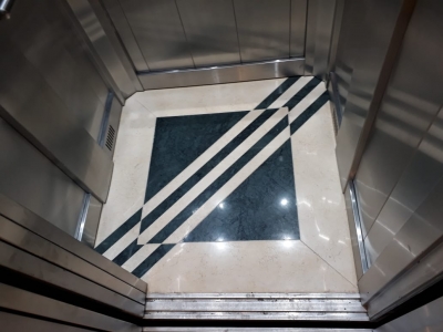 Piso de ascensor en marmol sahara combinado con mármol verde guatemala
